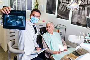 Oral surgeon showing a senior patient x rays of her mouth