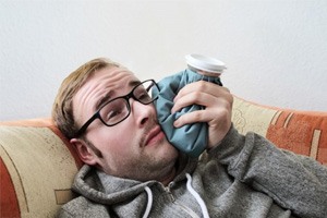 a patient using a cold compress on his cheek