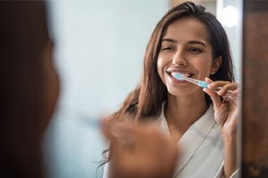 a patient brushing her teeth at home