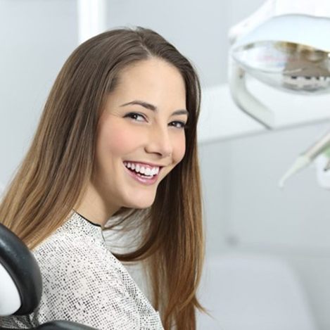 a patient smiling and visiting her dentist