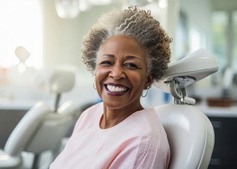 Older man in suit smiling with dental implants in Worcester