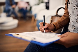 Patient filling out dental insurance information in office lobby