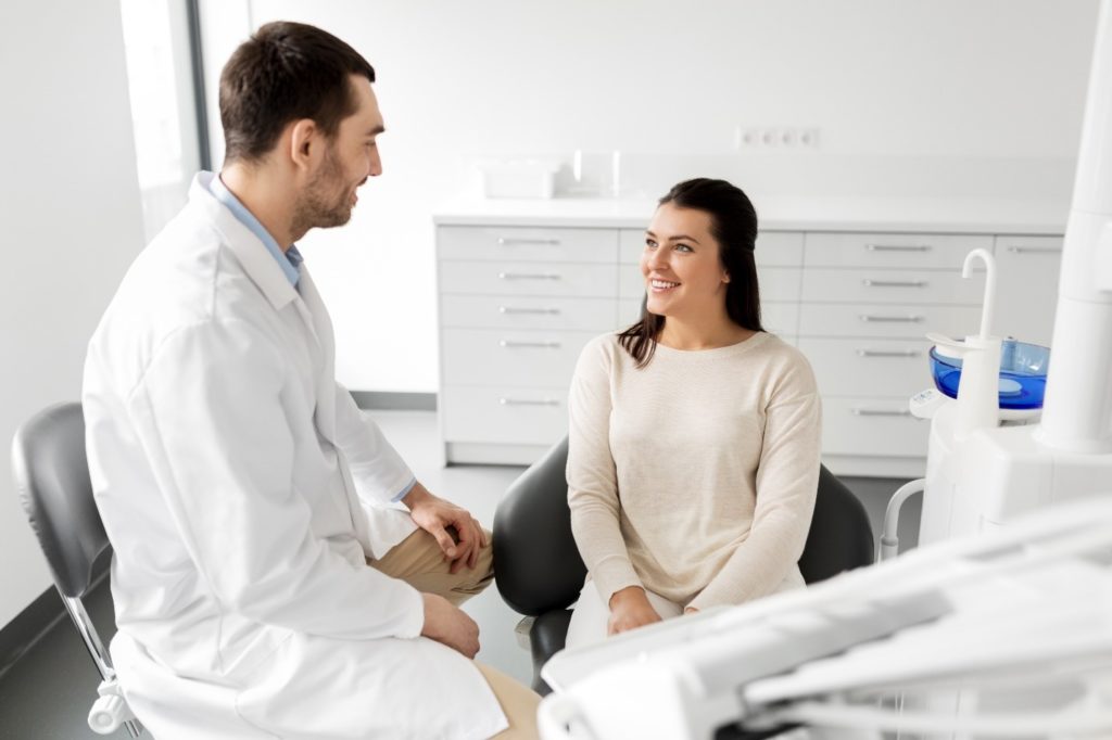 Dentist and patient talking in dental office