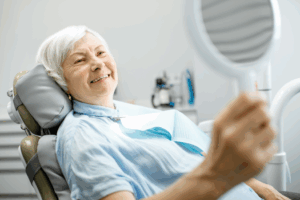 a woman smiling and admiring her new dental implant