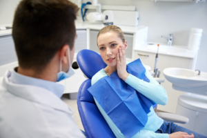 a patient holding their mouth in pain